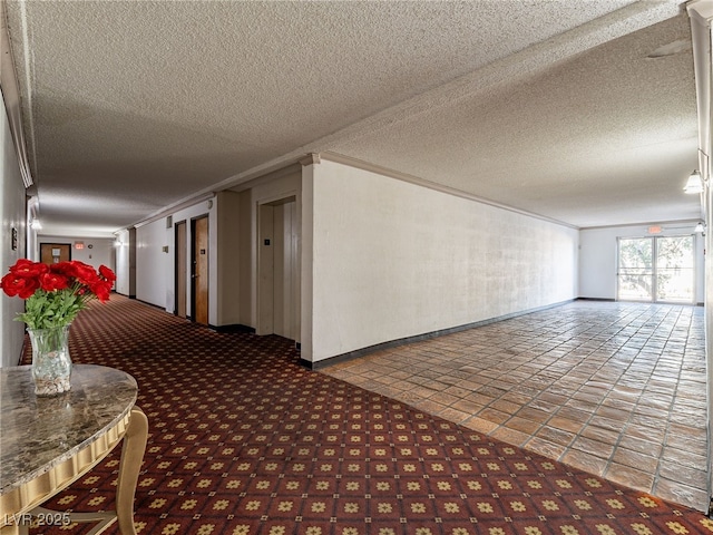 corridor with ornamental molding and a textured ceiling