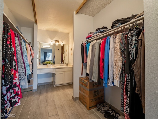 walk in closet with a sink and wood tiled floor