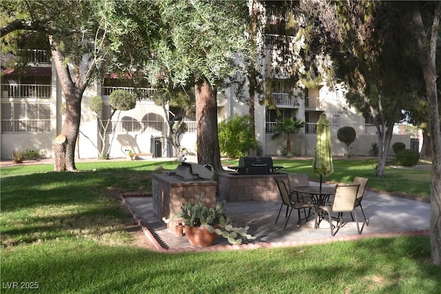 view of property's community with a patio and a lawn