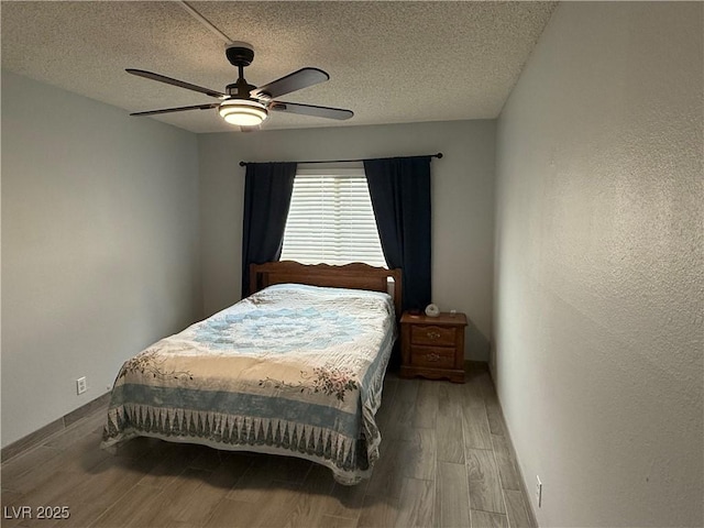 bedroom featuring a textured ceiling, ceiling fan, a textured wall, wood finished floors, and baseboards