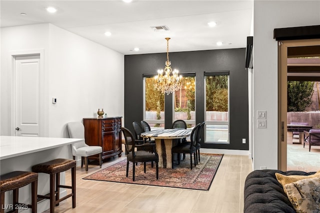 dining area with a chandelier and light hardwood / wood-style flooring