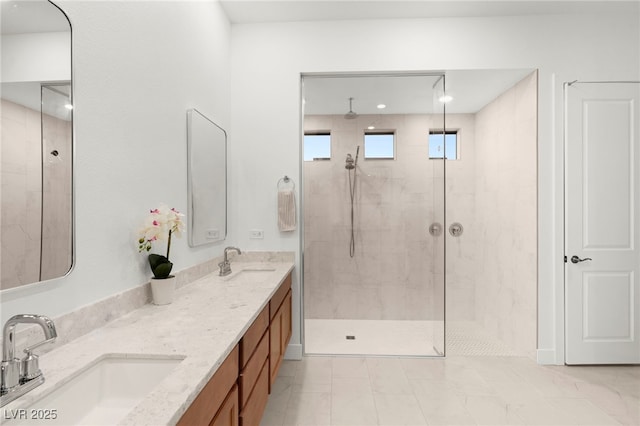 bathroom with tiled shower and vanity