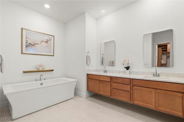 bathroom featuring a washtub and vanity