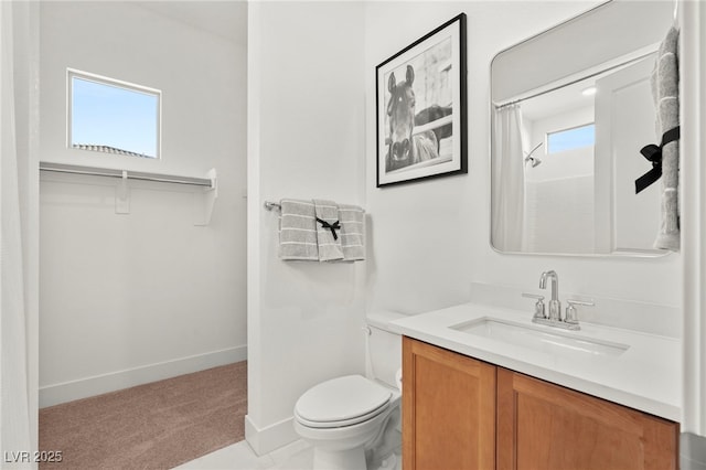 bathroom featuring walk in shower, a healthy amount of sunlight, toilet, and vanity