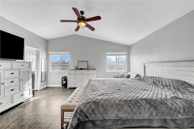 bedroom featuring ceiling fan, lofted ceiling, multiple windows, and dark tile patterned floors