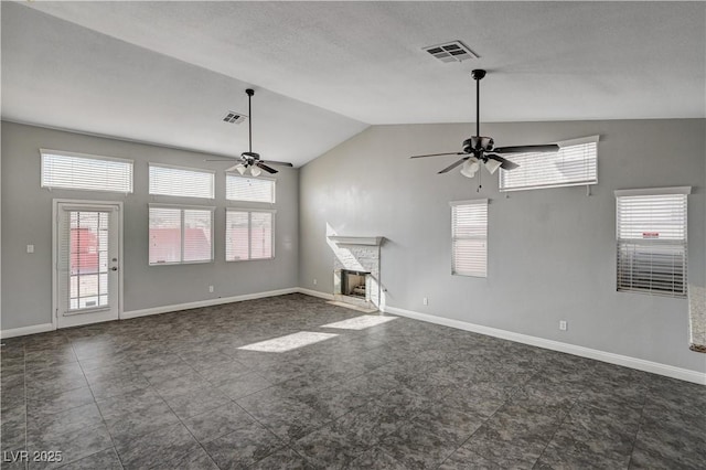 unfurnished living room featuring vaulted ceiling, a stone fireplace, and ceiling fan