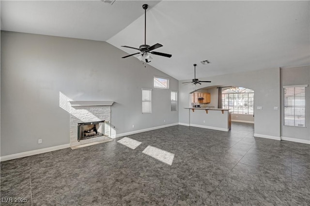 unfurnished living room with high vaulted ceiling and ceiling fan