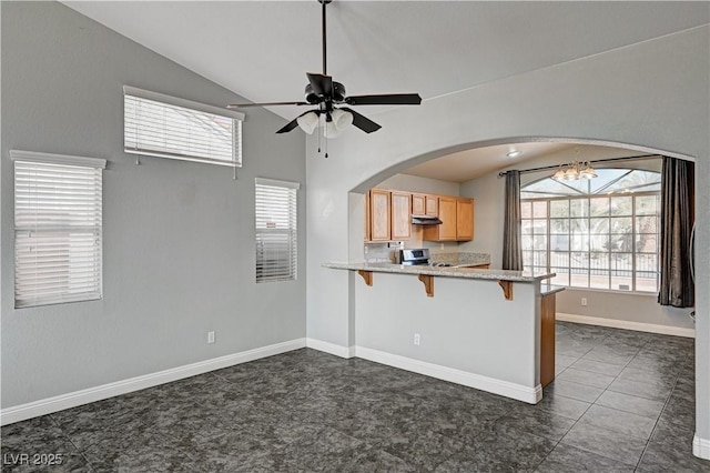 kitchen with a healthy amount of sunlight, stainless steel electric range oven, a kitchen breakfast bar, and lofted ceiling