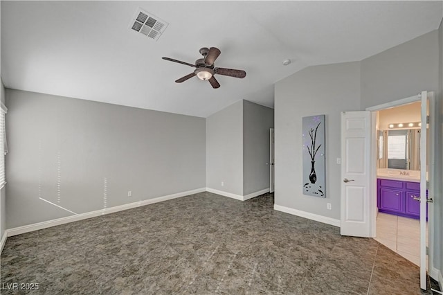 interior space featuring ceiling fan, lofted ceiling, connected bathroom, and sink