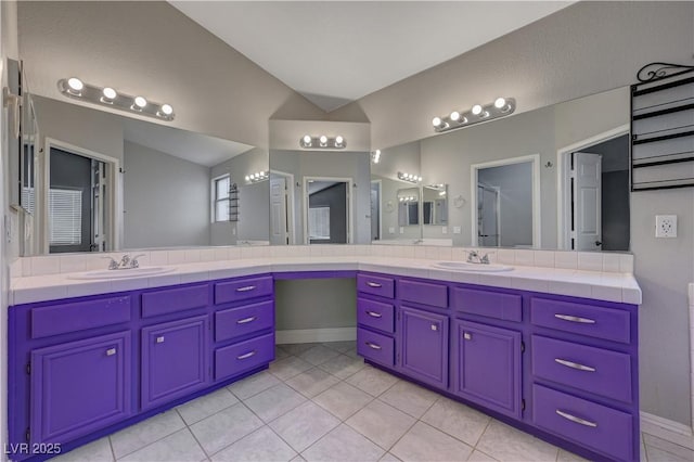 bathroom with vanity, vaulted ceiling, and tile patterned floors