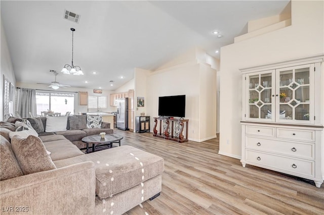 living room featuring high vaulted ceiling, light hardwood / wood-style flooring, and ceiling fan