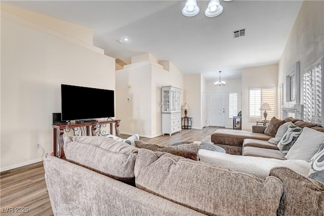 living room with hardwood / wood-style floors and a notable chandelier