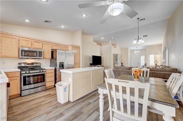 kitchen featuring light hardwood / wood-style flooring, lofted ceiling, light brown cabinetry, ceiling fan with notable chandelier, and appliances with stainless steel finishes