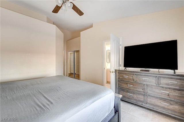 tiled bedroom with connected bathroom, ceiling fan, and lofted ceiling