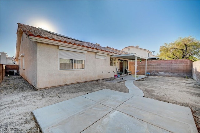 rear view of house with central AC unit and a patio