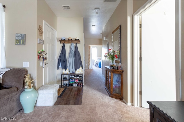 hallway with carpet flooring and visible vents