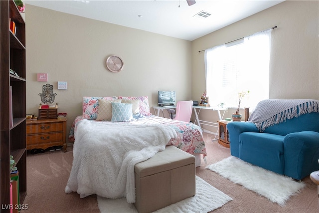 carpeted bedroom with visible vents and a ceiling fan