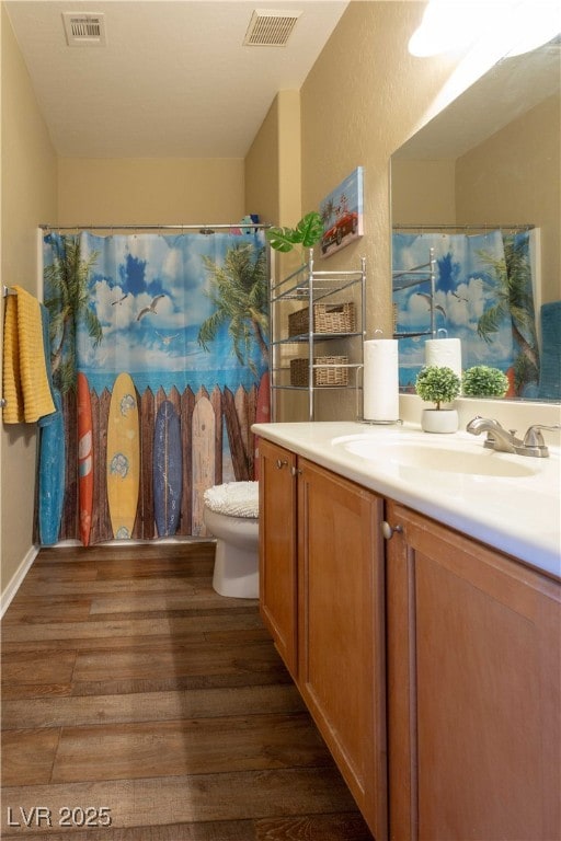 full bathroom featuring visible vents, toilet, wood finished floors, and vanity