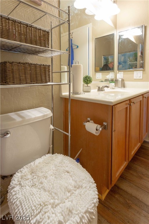 bathroom featuring toilet, vanity, and wood finished floors