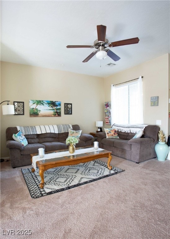 living room featuring carpet floors, visible vents, and a ceiling fan