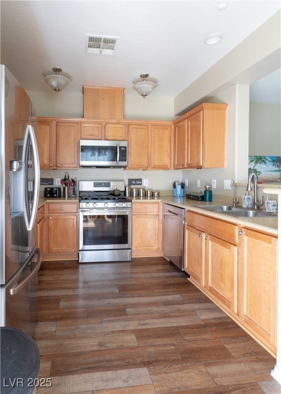 kitchen featuring dark wood-style floors, visible vents, a sink, light countertops, and appliances with stainless steel finishes