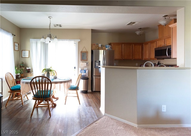 kitchen with a notable chandelier, visible vents, appliances with stainless steel finishes, and decorative light fixtures