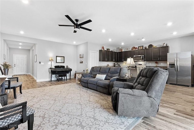 living room with ceiling fan and light hardwood / wood-style floors