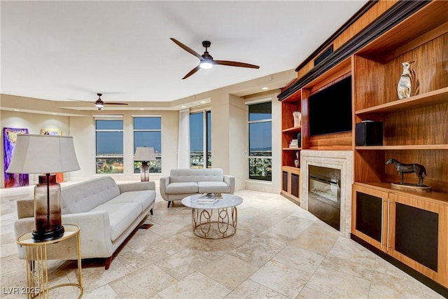 living room featuring ceiling fan and built in shelves