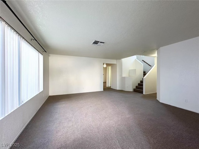 unfurnished room featuring carpet flooring and a textured ceiling