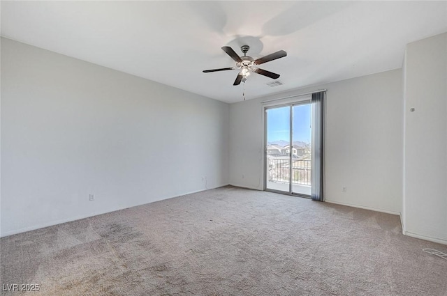 spare room with a ceiling fan, light colored carpet, and visible vents