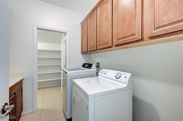 washroom with cabinet space, light tile patterned floors, and separate washer and dryer