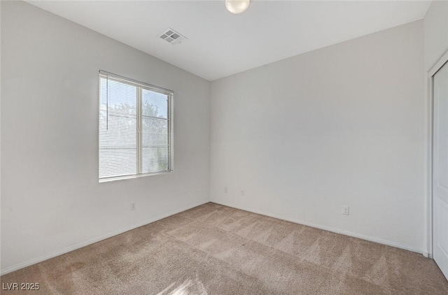 spare room with carpet floors, baseboards, and visible vents