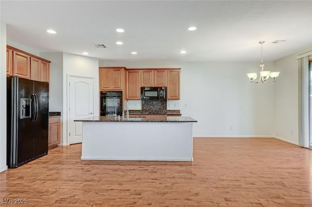 kitchen featuring a chandelier, visible vents, light wood-style floors, and black appliances