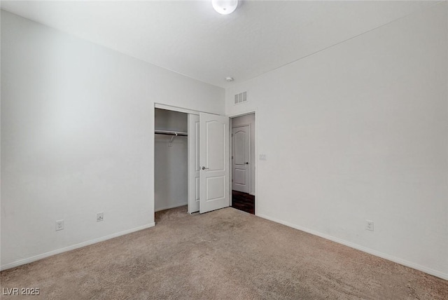 unfurnished bedroom featuring carpet floors, a closet, visible vents, and baseboards