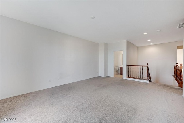 spare room featuring carpet floors, visible vents, and recessed lighting