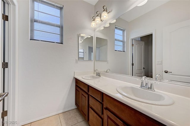 full bathroom with double vanity, tile patterned flooring, and a sink