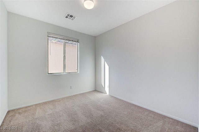 unfurnished room with baseboards, visible vents, and carpet flooring