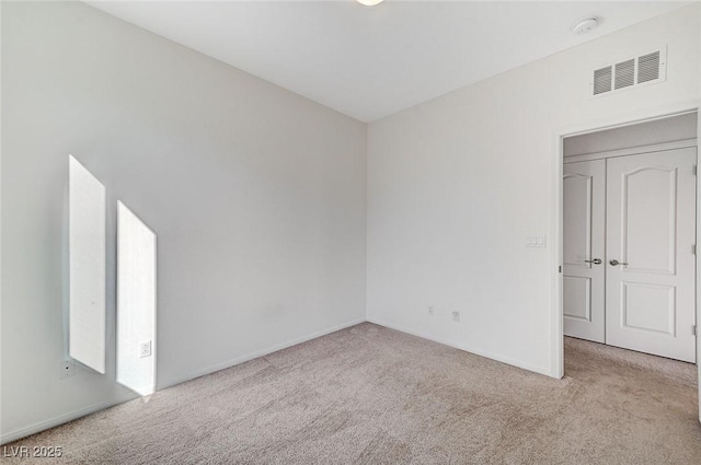 carpeted empty room featuring visible vents and baseboards