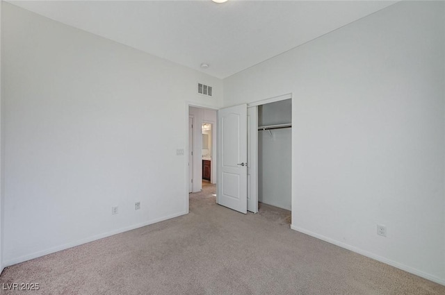 unfurnished bedroom featuring light colored carpet, a closet, visible vents, and baseboards