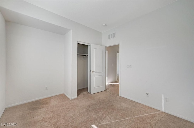 unfurnished bedroom with baseboards, a closet, visible vents, and light colored carpet