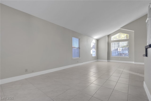 tiled spare room featuring lofted ceiling