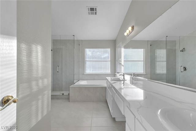 bathroom featuring vanity, vaulted ceiling, shower with separate bathtub, and tile patterned floors