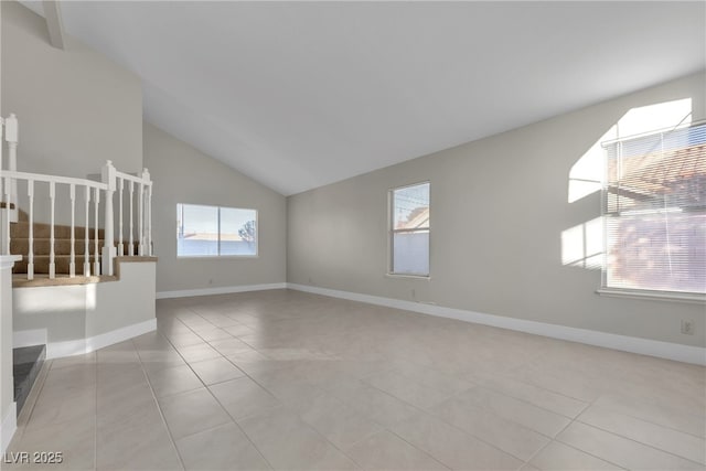 spare room featuring light tile patterned floors and vaulted ceiling