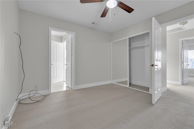 unfurnished bedroom featuring a closet, ceiling fan, and light carpet