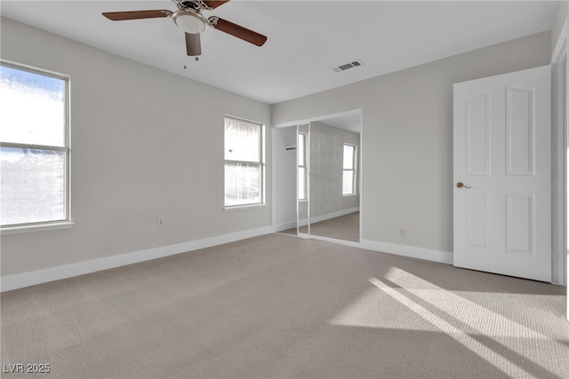 unfurnished bedroom with ceiling fan, a closet, and light carpet