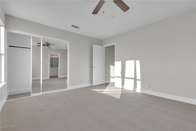 unfurnished bedroom featuring a closet, ceiling fan, and light colored carpet