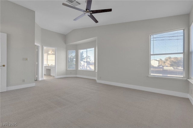 carpeted spare room with ceiling fan and vaulted ceiling