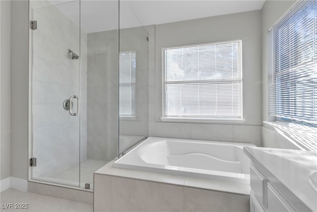 bathroom with tile patterned flooring, shower with separate bathtub, vanity, and a healthy amount of sunlight