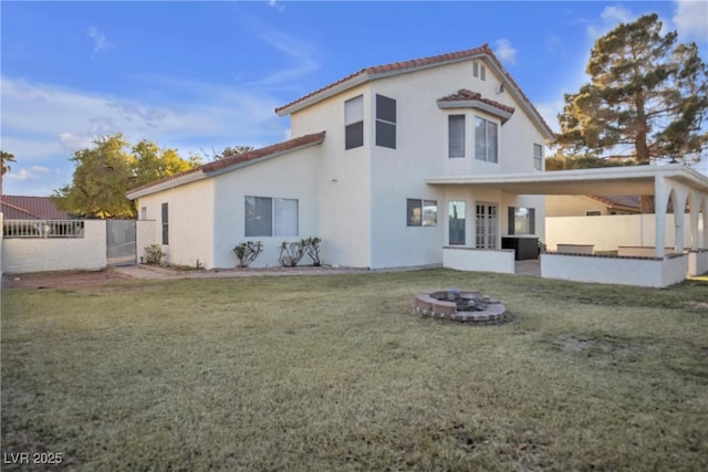 rear view of property featuring central AC unit, a fire pit, and a lawn