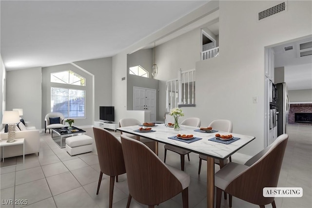 tiled dining area featuring high vaulted ceiling